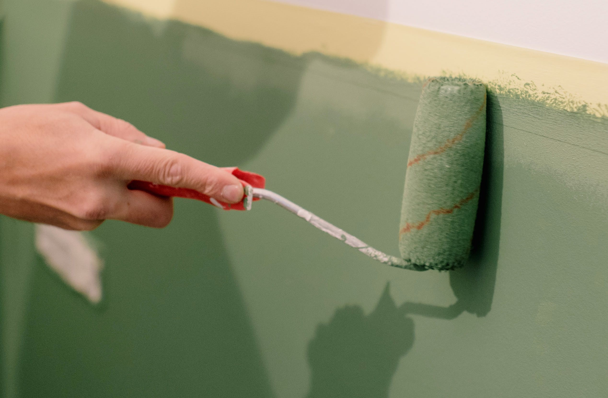 A hand painting a wall